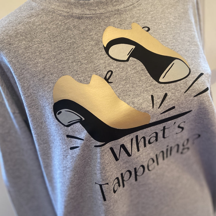 Gray t-shirt with gold tap shoes, “What’s Tappening?”.