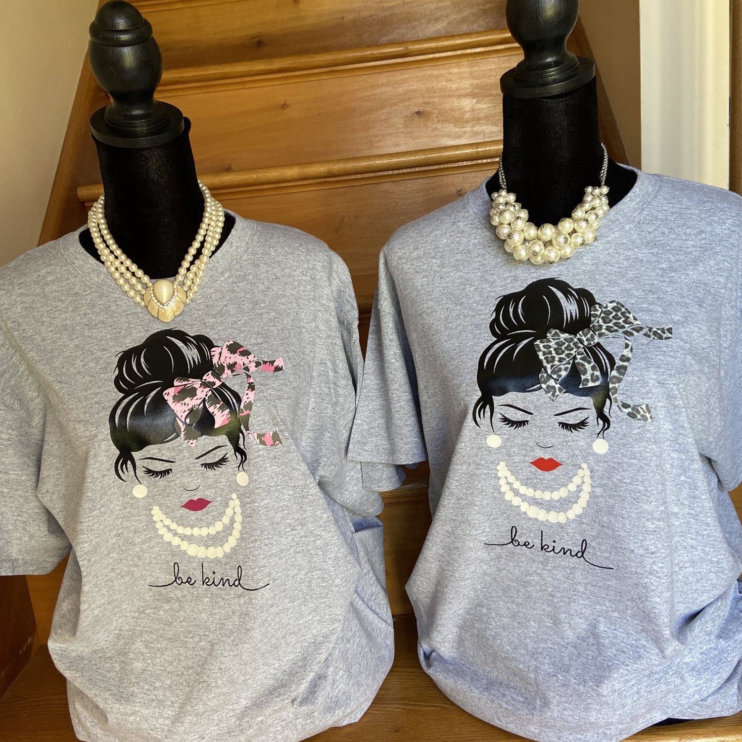 Two Woman with a bun and bow on a gray t-shirt, “Be Kind”.